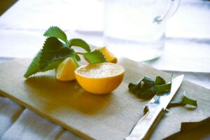 a lemon cut in half on a cutting board with a knife